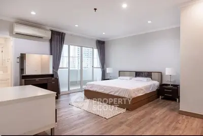 Spacious modern bedroom with balcony access and elegant furnishings