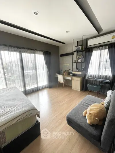 Spacious bedroom with modern decor, large windows, and cozy seating area, perfect for relaxation and productivity.