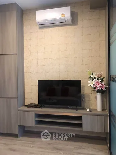 Modern living room with TV, air conditioning, and stylish decor