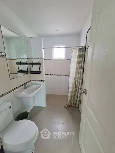 Modern bathroom with sleek fixtures and stylish shower curtain in a bright, airy space.