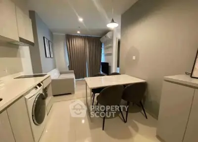 Modern open-layout kitchen and living area with sleek furniture and appliances.