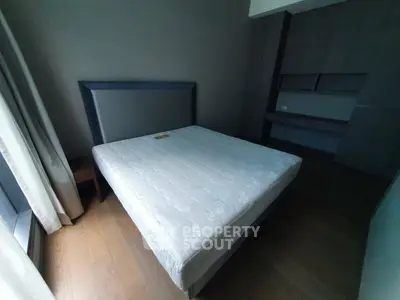 Spacious bedroom with modern design and large window for natural light.