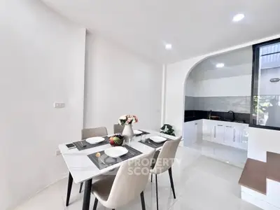 Modern dining area with elegant table setting and open kitchen layout