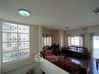Spacious living room with large windows and wooden flooring, perfect for family gatherings.