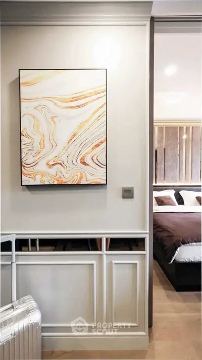 Modern bedroom with stylish decor and abstract art on the wall, showcasing elegant interior design.