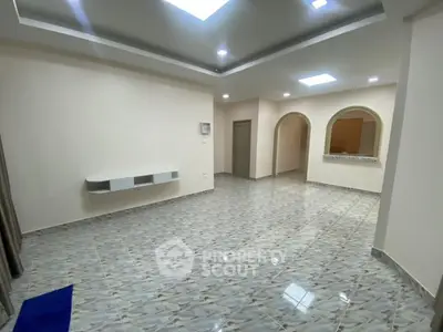 Spacious modern living room with elegant tile flooring and stylish ceiling design.