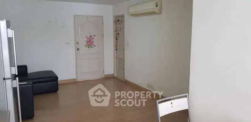 Spacious living room with air conditioning and modern flooring in a minimalist apartment.