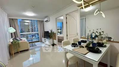 Modern open-plan living and dining area with stylish decor and city view.