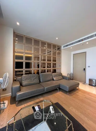 Modern living room with stylish gray sofa and wooden partition, featuring sleek design and cozy ambiance.