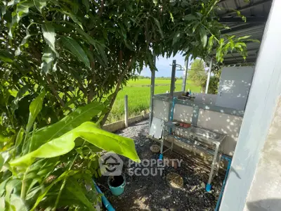 Charming outdoor kitchen with lush greenery and scenic field view, perfect for nature lovers.