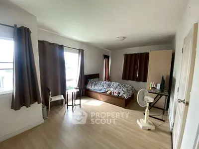 Spacious bedroom with natural light and modern furnishings