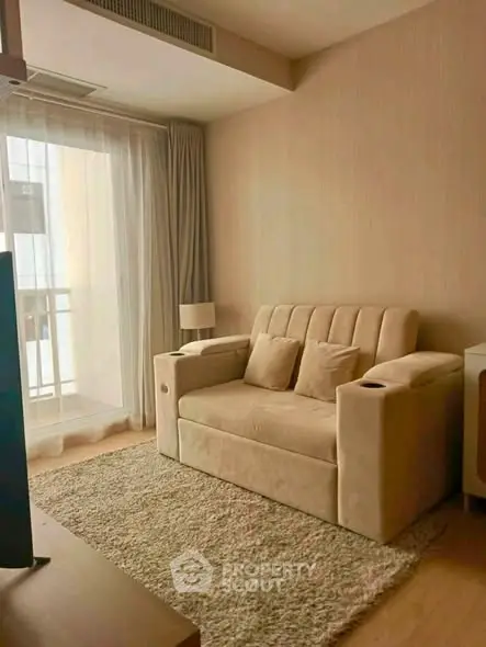 Cozy living room with beige sofa and natural light from balcony