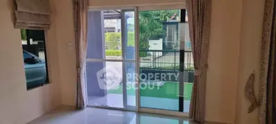 Spacious living room with sliding glass doors leading to a lush garden view.