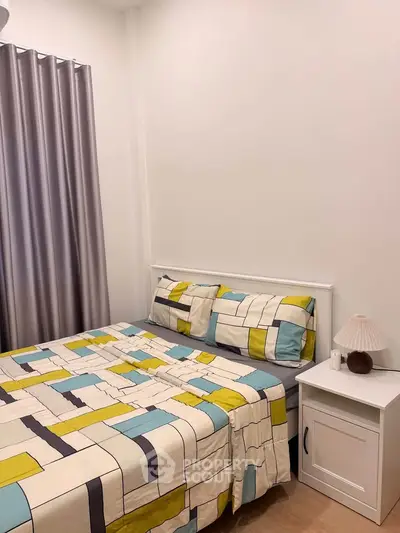 Cozy bedroom with modern decor and colorful bedding in a stylish apartment.