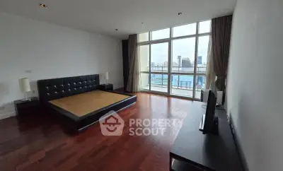 Spacious bedroom with city view and modern furnishings in luxury apartment