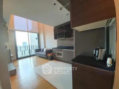 Modern open-layout kitchen and living room with balcony view in high-rise apartment.