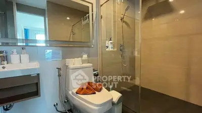 Modern bathroom with glass shower and sleek fixtures in a contemporary home.