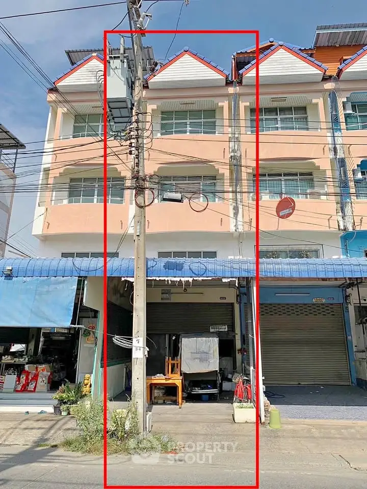 Commercial building with multiple floors and street-level shops for sale.