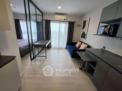 Modern apartment interior with stylish living room and bedroom separation, featuring sleek furniture and large windows.