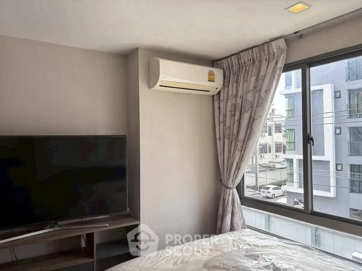 Modern bedroom with air conditioning and large window offering city view