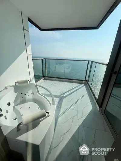 Luxurious balcony with ocean view and private jacuzzi, perfect for relaxation and enjoying the sea breeze.