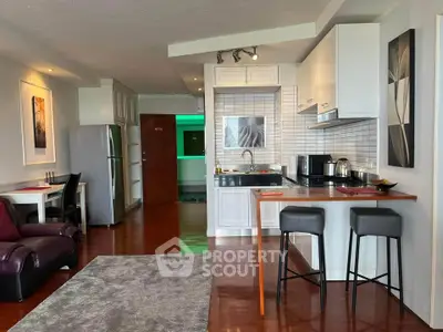 Modern open-layout kitchen and living area with stylish decor and hardwood floors.