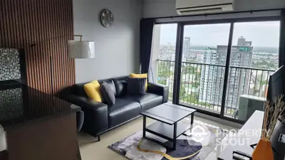 Modern living room with city view, stylish decor, and balcony access in high-rise apartment.