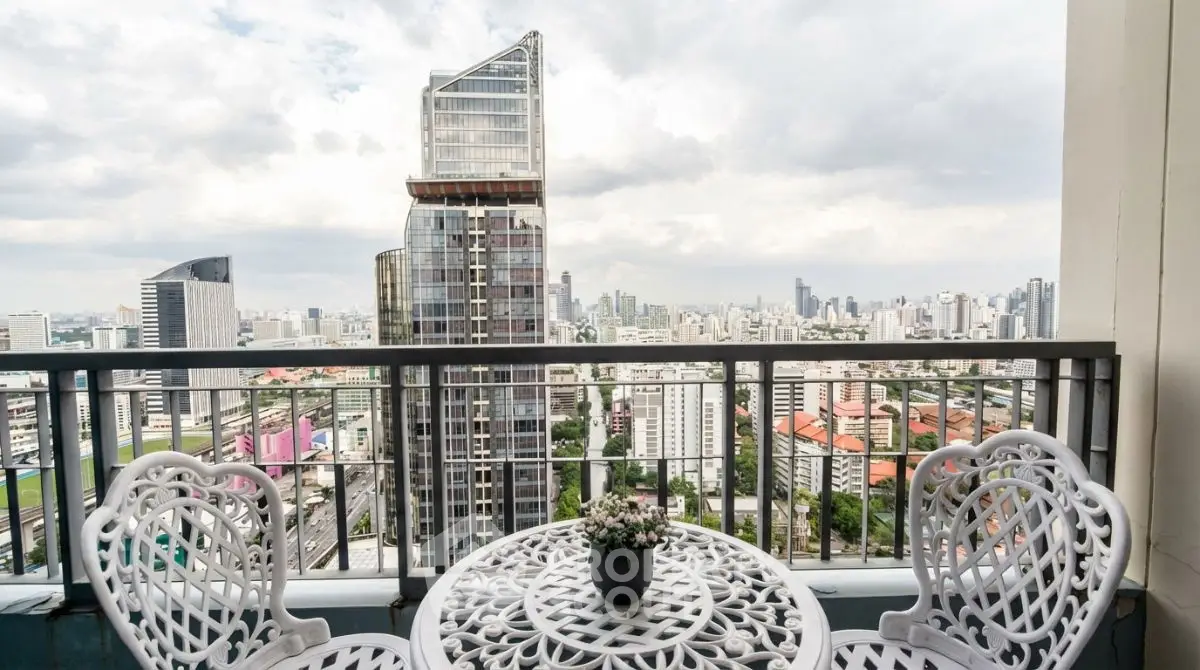 Stunning cityscape view from a high-rise balcony with elegant outdoor seating.