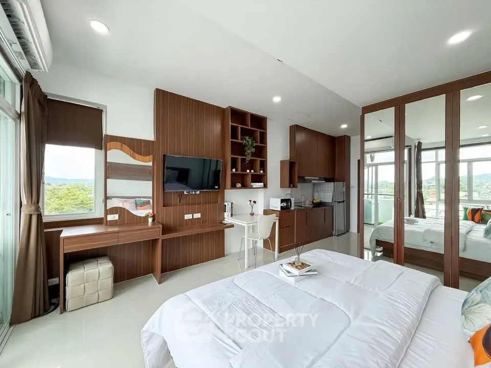 Modern bedroom with sleek design, featuring a large window, built-in TV, and stylish wooden furniture.