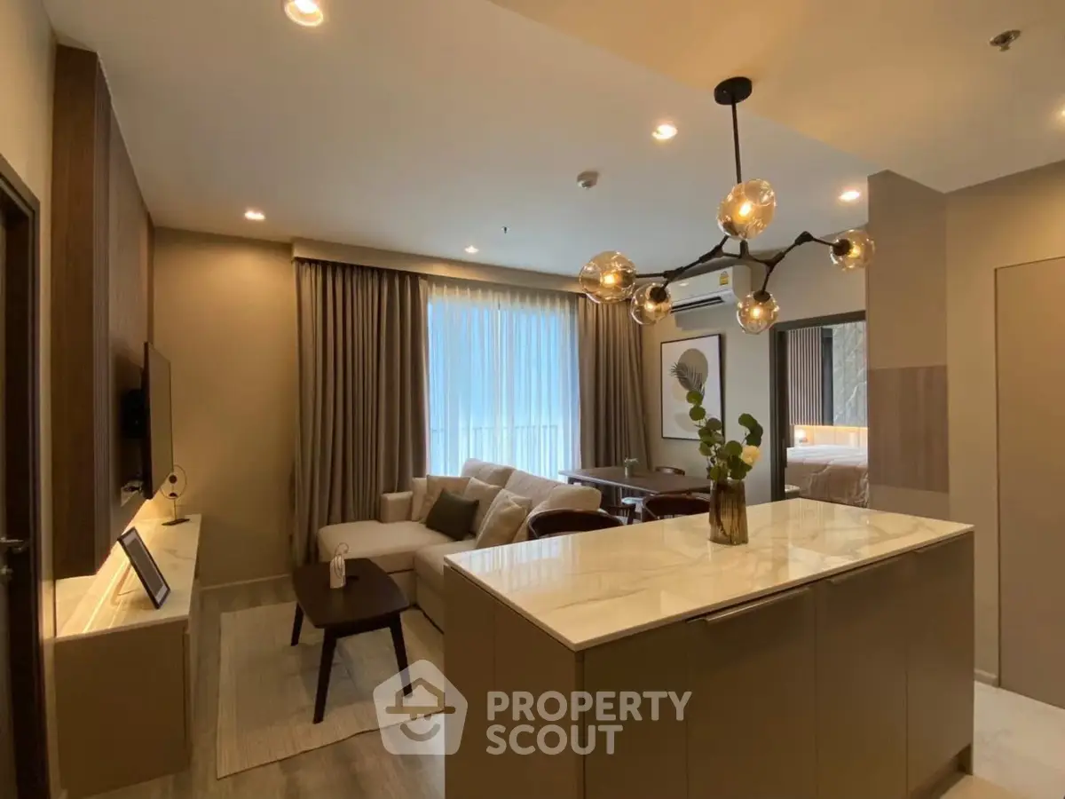 Modern living room with stylish lighting and open layout, featuring a cozy sofa and elegant decor.