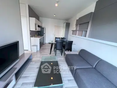 Modern living room with sleek furniture and open kitchen layout in a stylish apartment.