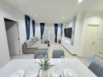 Modern living room with elegant decor and open layout, featuring a cozy sofa and stylish dining area.