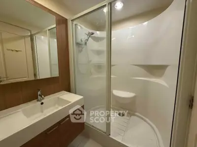 Modern bathroom with sleek shower and stylish vanity in contemporary apartment.