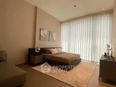 Luxurious bedroom with modern decor and large window offering natural light