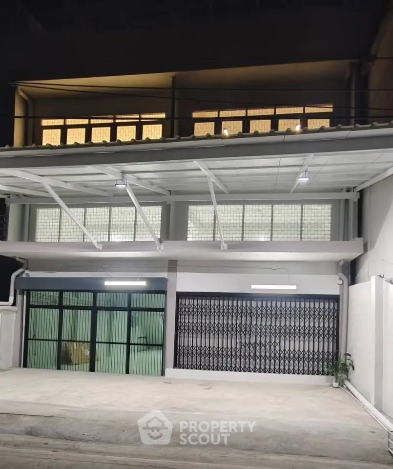 Modern building exterior with large windows and secure gate, ideal for commercial or residential use.