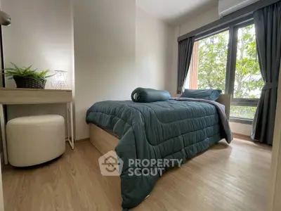 Cozy bedroom with large window and modern decor, perfect for relaxation and comfort.