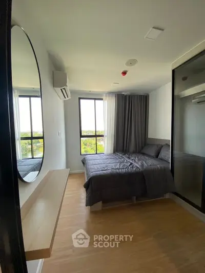 Modern bedroom with large window and stylish decor in a contemporary apartment.