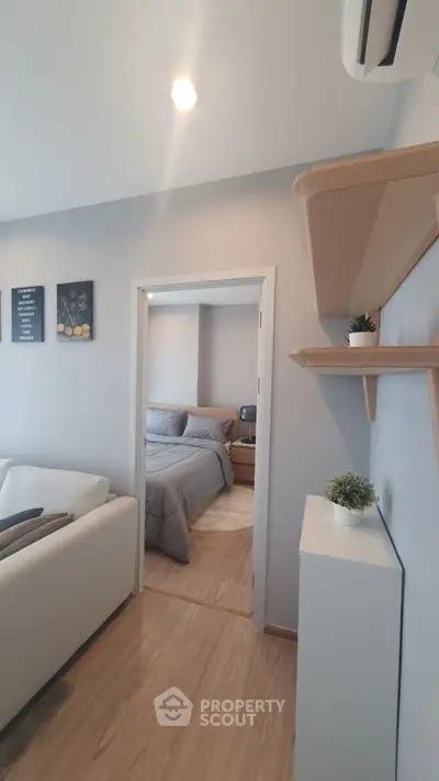 Modern living room with cozy bedroom view, stylish decor, and wooden flooring.