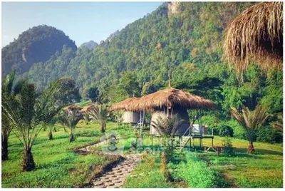 Charming eco-friendly huts with lush mountain backdrop, perfect for nature retreats.