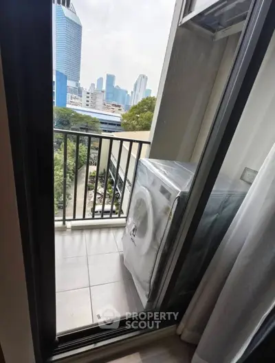Modern apartment balcony with city view and washing machine