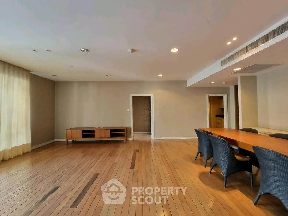 Spacious living room with elegant wooden flooring and modern dining area