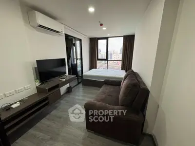 Modern studio apartment with city view, featuring cozy living area and sleek design.