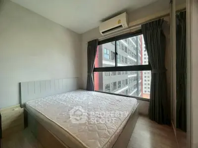 Cozy bedroom with large window and city view, featuring modern air conditioning unit.