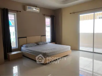 Spacious bedroom with large windows and balcony access in modern home.