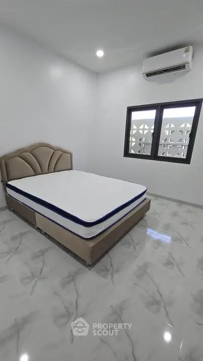 Modern bedroom with sleek marble flooring and air conditioning, featuring a stylish bed and large window.