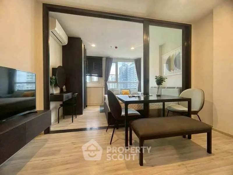 Modern living room with dining area and large windows in a stylish apartment.