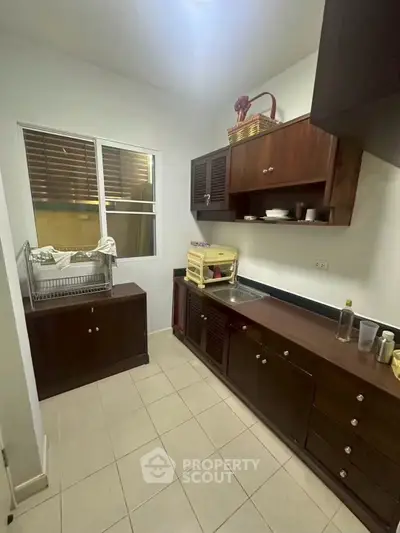 Charming kitchen with dark wood cabinets and ample counter space, perfect for culinary enthusiasts.