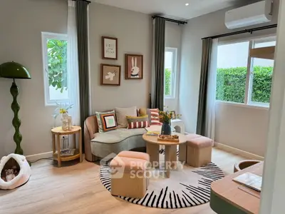 Charming living room with modern decor and natural light, featuring cozy seating and stylish accents.