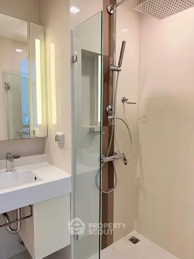 Modern bathroom with sleek shower and elegant sink in a contemporary apartment.