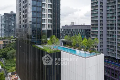 Luxurious high-rise building with rooftop infinity pool and lush greenery, offering stunning city views.
